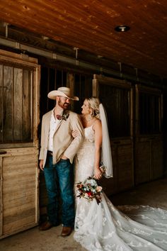 a bride and groom are standing in the barn