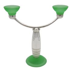 a green candle holder with two candles on it's sides and one light in the middle