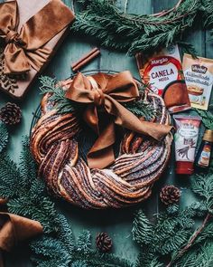 an assortment of christmas food on a wooden table with pine cones, cinnamon sticks and other holiday foods