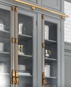 a kitchen with gray cabinets and gold handles