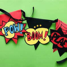 two paper banners with the words pow boom and spider man on them hanging from a string