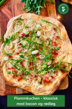 a wooden cutting board topped with a pizza covered in veggies on top of it