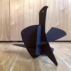 an origami bird sitting on top of a wooden floor