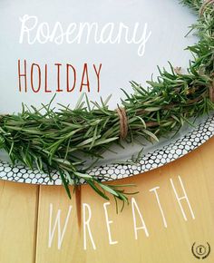 rosemary holiday wreath on a wooden table with the words rosemary holiday written in white letters