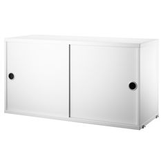 a white cabinet with two black knobs on the doors