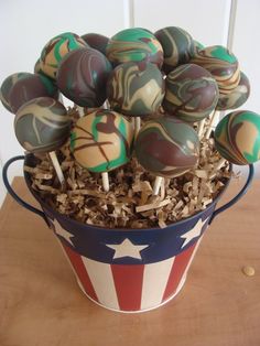 a bucket filled with cake pops on top of a wooden table