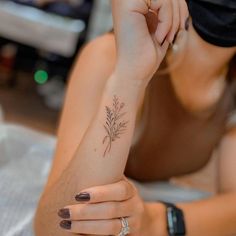 a woman with a flower tattoo on her left arm and right hand resting on the floor