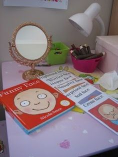 there is a pink table with books and a mirror on it that says happy faces