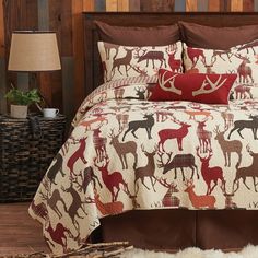 a bed covered in deer and red pillows