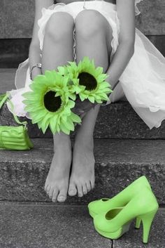 a black and white photo of a woman's feet with sunflowers