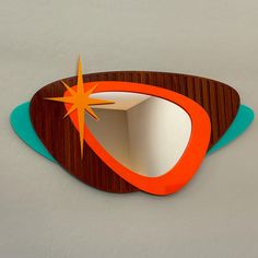 a mirror with an orange star on the top and blue bottom, sitting on a white surface