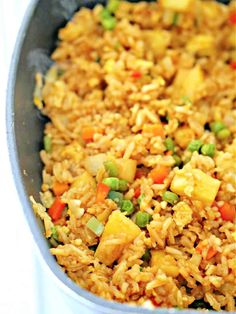 a pan filled with rice and vegetables on top of a table