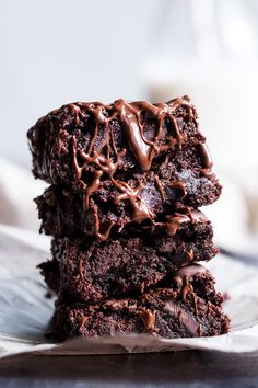 three brownies stacked on top of each other with chocolate drizzled on them