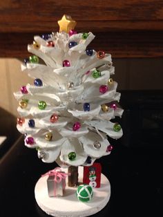 a small white christmas tree sitting on top of a table