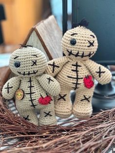 two crocheted teddy bears sitting next to each other on top of a table