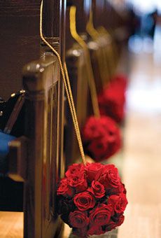 red roses are tied to pews in a church