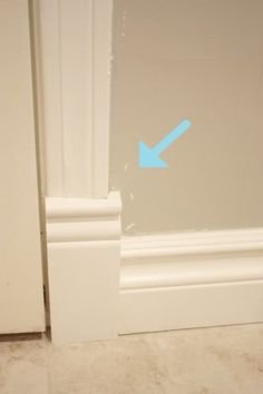 an arrow painted on the side of a white door with blue arrows pointing in opposite directions