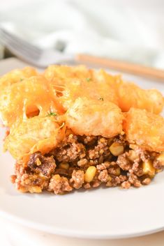 a white plate topped with fried food next to a fork