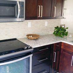 a kitchen with wooden cabinets and white marble counter tops is pictured in this image, there is a basket on top of the stove