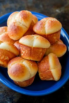 a blue plate filled with bread rolls on top of a table