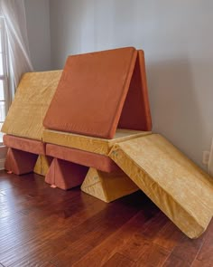 an orange couch sitting on top of a wooden floor