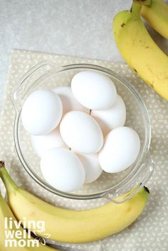 eggs in a glass bowl next to bananas on a cloth with polka dot tablecloth