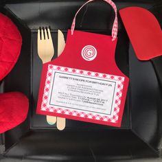 a red and white plate topped with a fork and knife next to a red stuffed animal