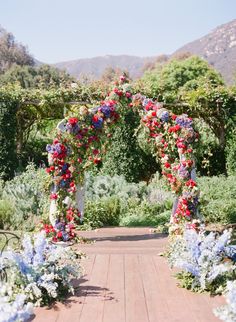 an outdoor wedding ceremony with flowers and greenery on the walkway leading to the mountains