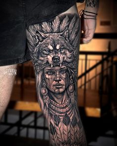 a man's leg with tattoos on it and an image of a wolf in the background