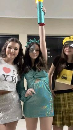 three girls are dressed up and posing for the camera with their arms in the air