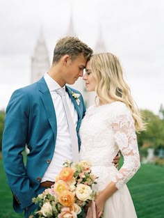 a man and woman are kissing in front of a castle with the bride holding her bouquet