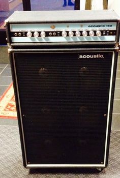 an old amp sitting on the floor in front of a wall with a sign that says acoustic