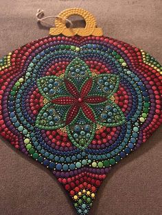 a colorful ornament hanging from a hook on top of a carpeted floor