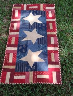 an american flag quilt is laying on the grass with stars and stripes painted on it