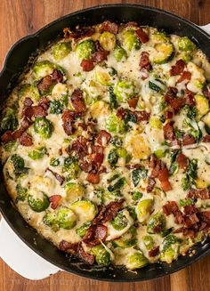 brussel sprouts and bacon in a skillet on a wooden table