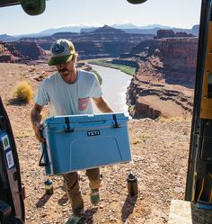 a man holding a blue cooler in his hand