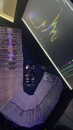 a pile of money sitting next to a computer monitor