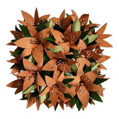 a bunch of brown paper flowers with white dots on them and green leaves in the center