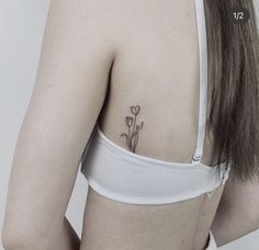 the back of a woman's bra with flowers tattooed on her left side ribcage