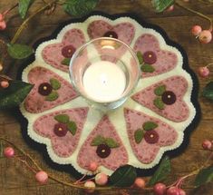 a candle sitting on top of a pink plate