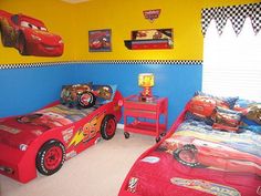 two beds in a room with cars painted on the walls