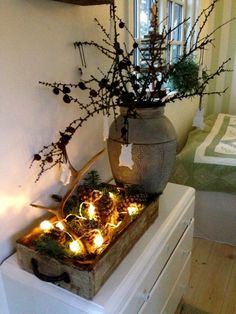 a vase filled with flowers sitting on top of a white dresser next to a window