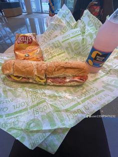 a sandwich and drink sitting on top of a wrapper