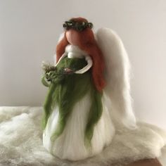 an angel figurine sitting on top of a pile of wool