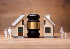 a judge's gavel next to a house and family