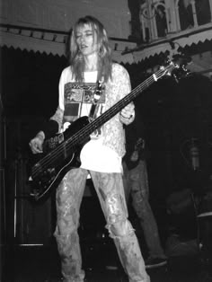 a man with long hair holding a guitar