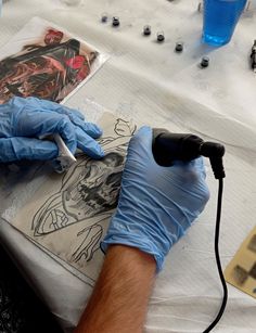 a man in blue gloves is working on an art project