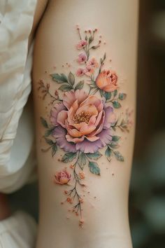 a woman's thigh with flowers and leaves on it