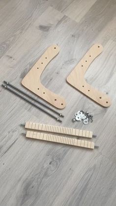 the tools needed to make a wooden guitar stand are laid out on a wood floor