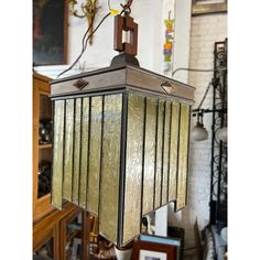 a light fixture hanging from the ceiling in a room with other furniture and decor items